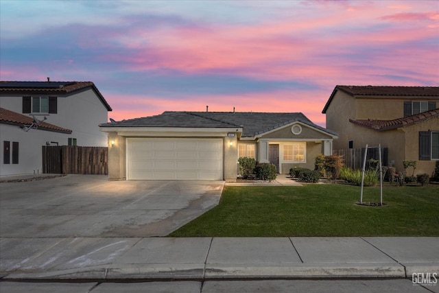 view of front of home featuring a yard, stucco siding, concrete driveway, an attached garage, and fence