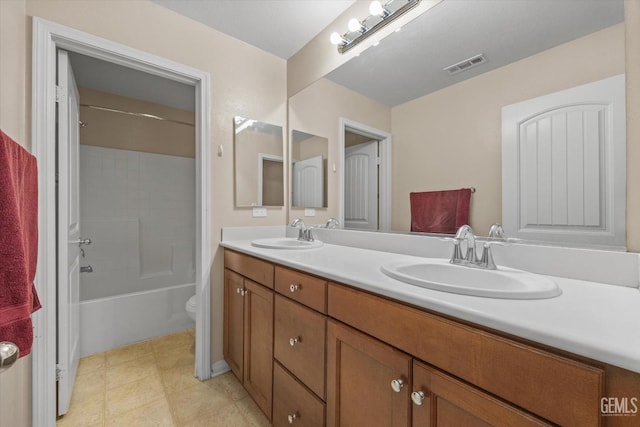 full bathroom with toilet, double vanity, a sink, and visible vents