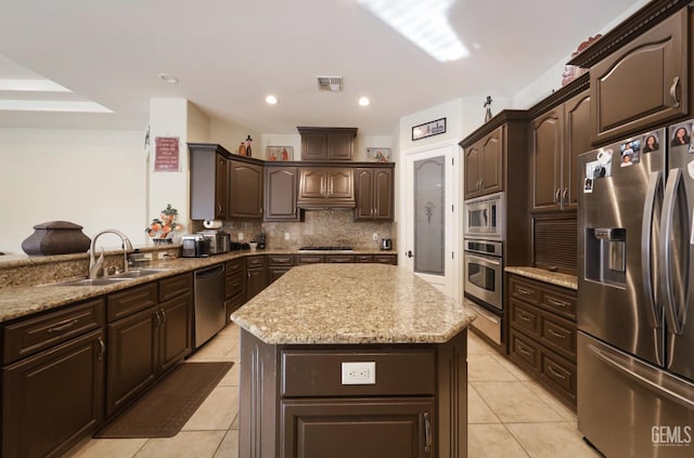 1705 Briercliff Ct, Bakersfield, CA 93311 - kitchen with stainless steel appliances, a warming drawer, dark brown cabinets, a kitchen island, and a sink