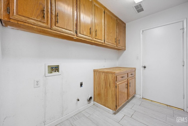 clothes washing area featuring cabinets, hookup for a washing machine, hookup for a gas dryer, and electric dryer hookup