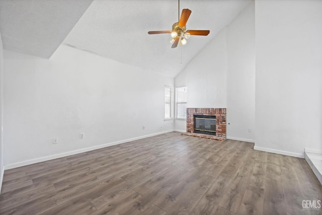 unfurnished living room featuring ceiling fan, a fireplace, high vaulted ceiling, and hardwood / wood-style floors