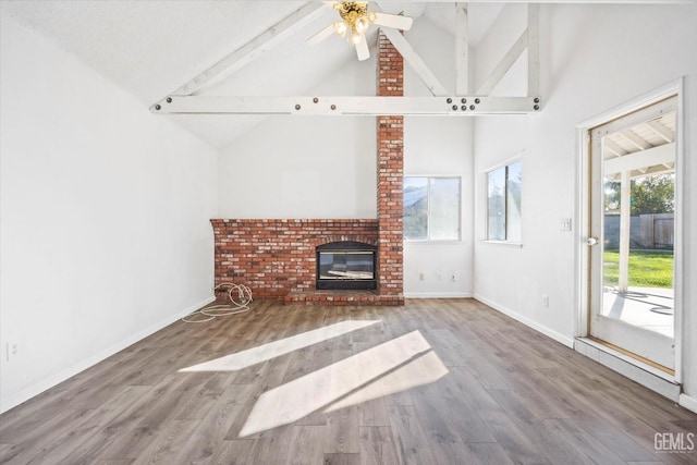 unfurnished living room featuring high vaulted ceiling, a brick fireplace, ceiling fan, beamed ceiling, and wood-type flooring