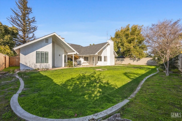 rear view of house featuring a lawn