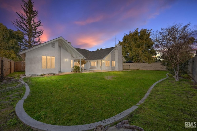 back house at dusk with a yard