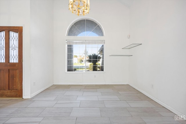 entrance foyer featuring a towering ceiling and an inviting chandelier