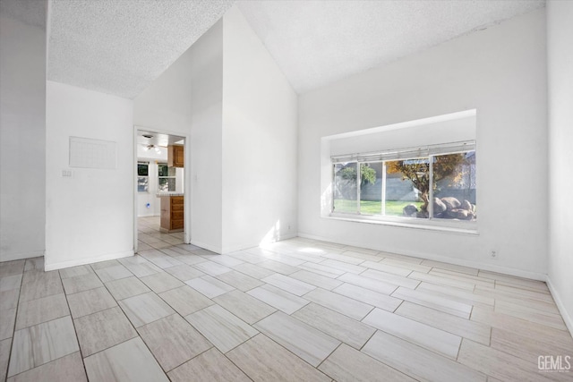 unfurnished room featuring a textured ceiling, ceiling fan, and lofted ceiling