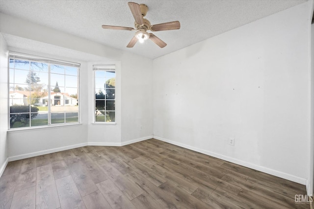 spare room featuring hardwood / wood-style flooring, ceiling fan, and a textured ceiling