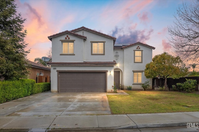 mediterranean / spanish house featuring fence, driveway, stucco siding, a garage, and a tiled roof