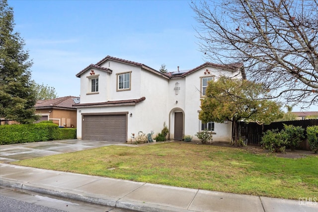 mediterranean / spanish home featuring stucco siding, a tile roof, roof mounted solar panels, fence, and an attached garage