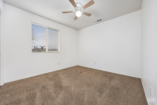 carpeted empty room with visible vents and a ceiling fan