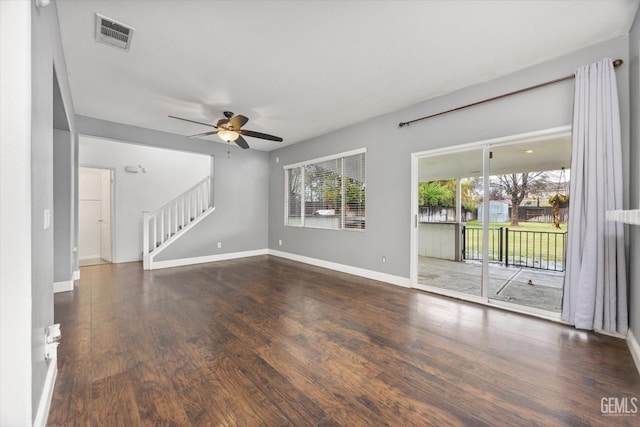 unfurnished living room with visible vents, a ceiling fan, wood finished floors, stairway, and baseboards