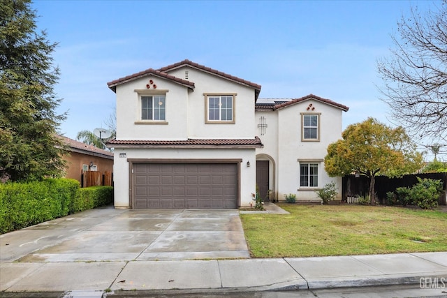 mediterranean / spanish home with fence, concrete driveway, a tile roof, a front yard, and stucco siding