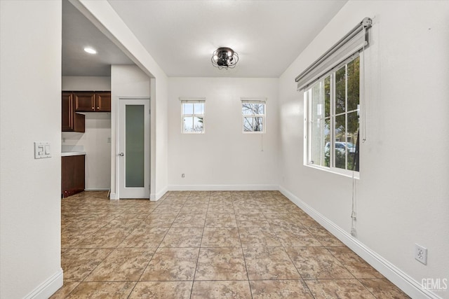 empty room with light tile patterned floors and baseboards