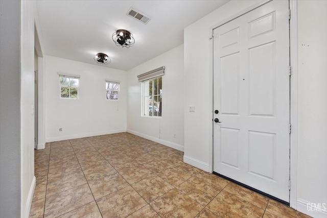 foyer with light tile patterned flooring, baseboards, and visible vents