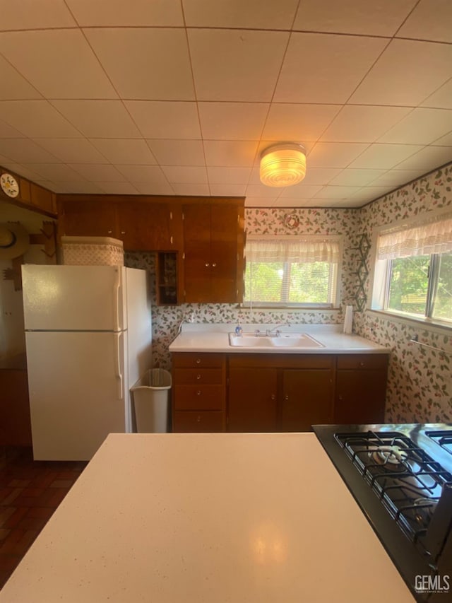 45904 Carlin Dr, Posey, CA 93260 - kitchen with freestanding refrigerator, wallpapered walls, light countertops, gas stovetop, and brown cabinets