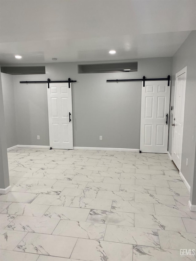 unfurnished room featuring a barn door