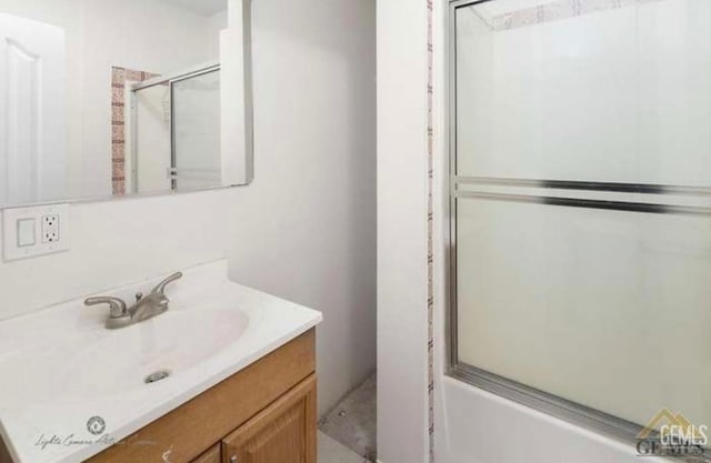 bathroom with enclosed tub / shower combo and vanity