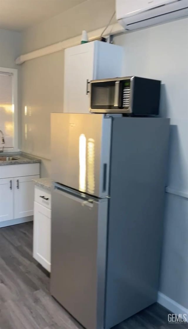 kitchen with stainless steel appliances, sink, white cabinets, and dark hardwood / wood-style floors