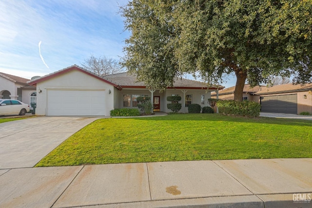 view of front of house with stucco siding, a front lawn, a tile roof, concrete driveway, and an attached garage