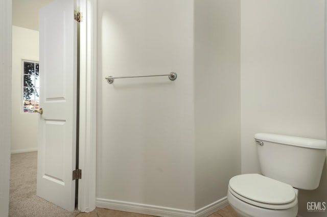 bathroom with toilet and baseboards