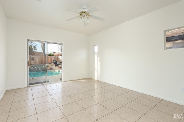 spare room featuring light tile patterned floors, baseboards, and ceiling fan