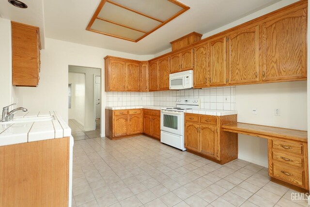 kitchen with decorative backsplash, white appliances, tile counters, and a sink