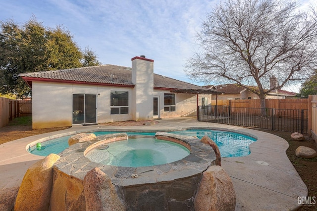 view of swimming pool with a patio, a fenced backyard, and a pool with connected hot tub