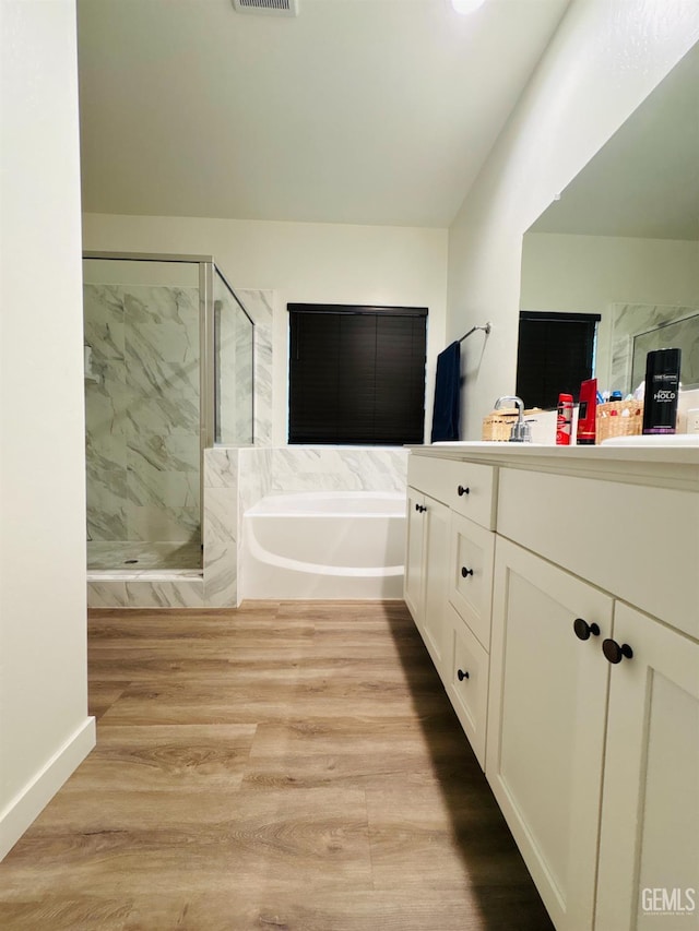 8410 Avon St, Bakersfield, CA 93314 - bathroom featuring vanity, a bath, a marble finish shower, and wood finished floors