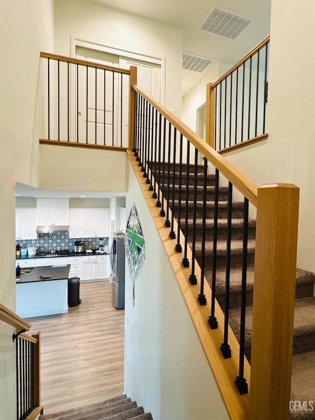 8410 Avon St, Bakersfield, CA 93314 - stairs featuring wood finished floors and a towering ceiling