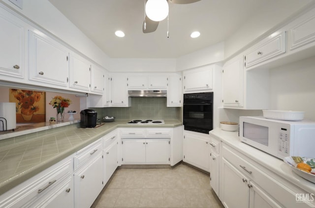 kitchen with white appliances, ceiling fan, under cabinet range hood, white cabinetry, and backsplash