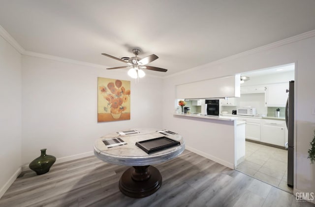 interior space featuring ceiling fan, ornamental molding, light wood-style flooring, and baseboards