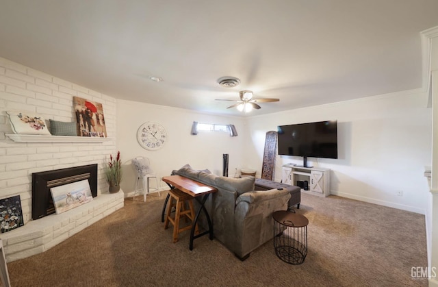 living area featuring dark colored carpet, a brick fireplace, visible vents, and a ceiling fan