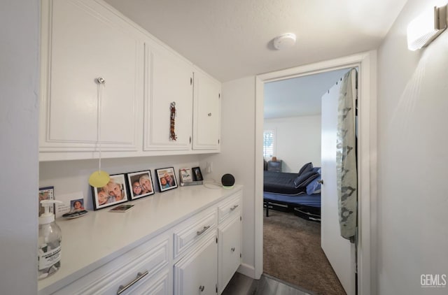 hall with dark colored carpet