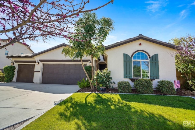 mediterranean / spanish-style house with a garage, driveway, a front lawn, and stucco siding