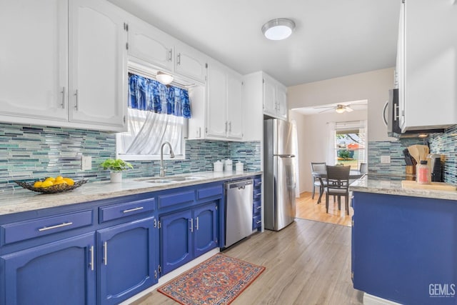 2702 Worthington Ave, Bakersfield, CA 93308 - kitchen featuring blue cabinetry, a ceiling fan, white cabinets, tasteful backsplash, and appliances with stainless steel finishes
