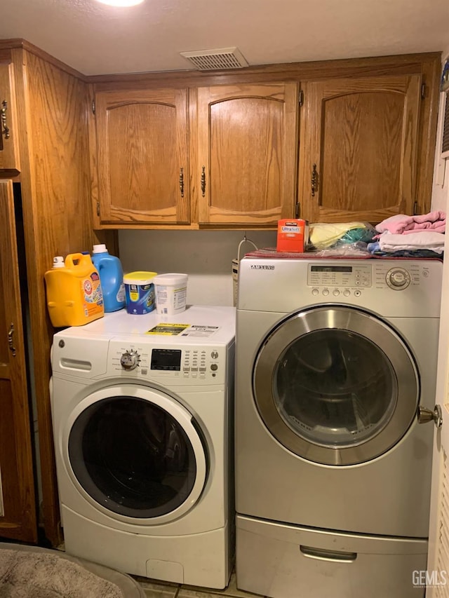 laundry area with cabinets and washer and clothes dryer