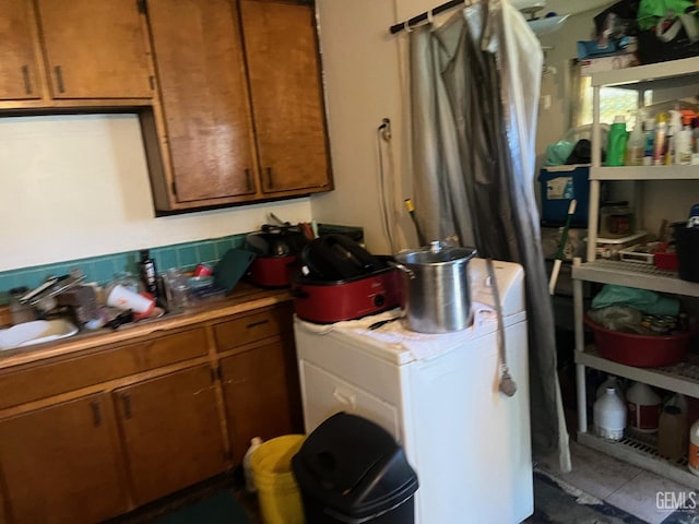 laundry area with sink, tile patterned floors, and washer / dryer