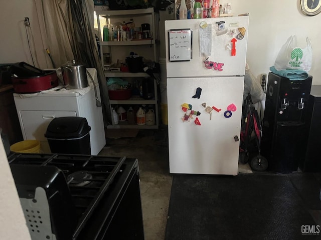 kitchen featuring washer / clothes dryer, white refrigerator, gas stove, and concrete flooring