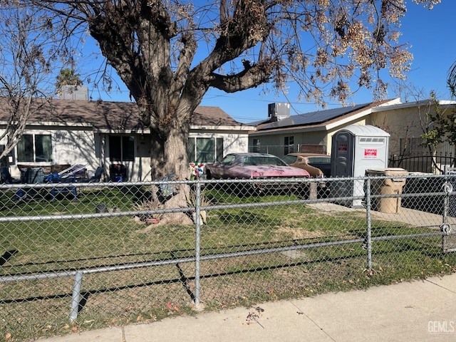 ranch-style house featuring a front lawn and solar panels