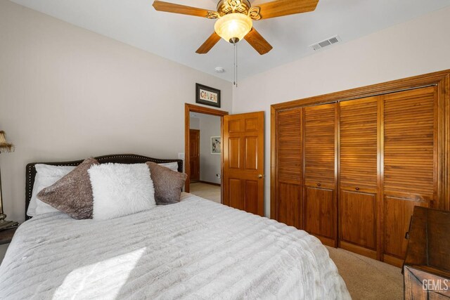 bedroom with ceiling fan, a closet, and light carpet