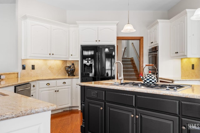 kitchen featuring white cabinetry, white gas cooktop, stainless steel dishwasher, pendant lighting, and black fridge with ice dispenser