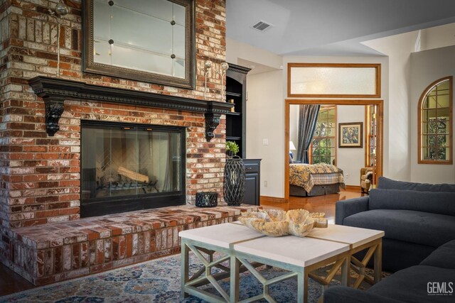 living room featuring built in features and a fireplace