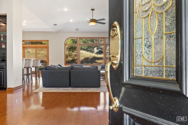 living room with hardwood / wood-style flooring, ceiling fan, and lofted ceiling