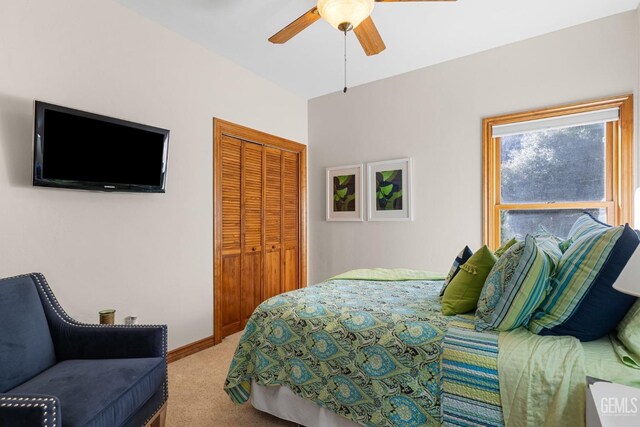 carpeted bedroom featuring ceiling fan and a closet