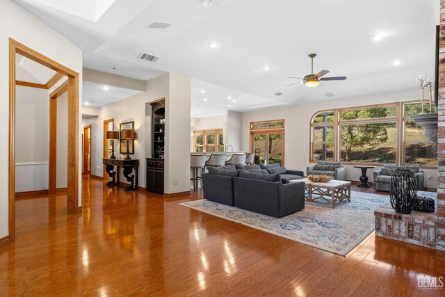 living room with ceiling fan, hardwood / wood-style floors, and lofted ceiling