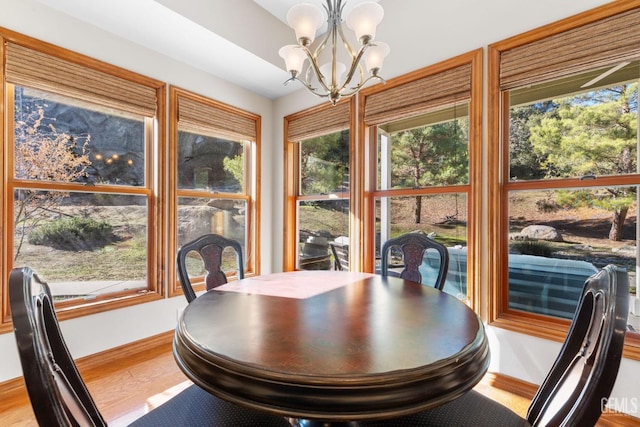 dining area with hardwood / wood-style floors and a chandelier