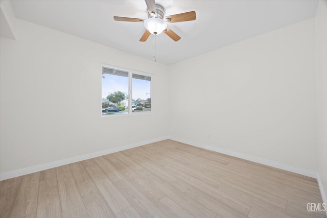 spare room with light wood-style flooring, baseboards, and ceiling fan