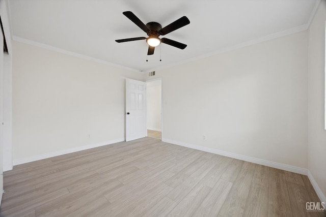 spare room with ceiling fan, visible vents, baseboards, light wood-style floors, and ornamental molding