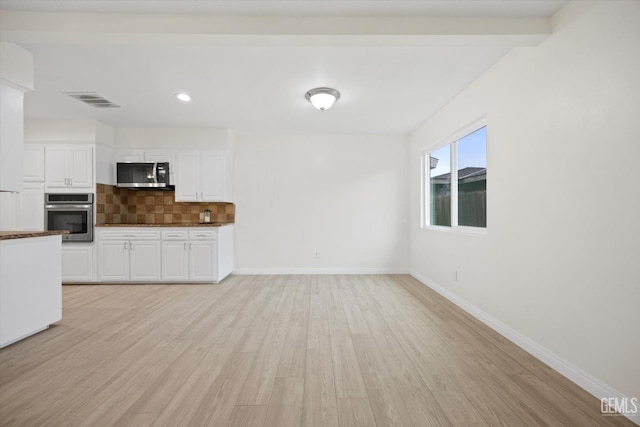 kitchen featuring tasteful backsplash, visible vents, white cabinets, stainless steel appliances, and light wood-type flooring