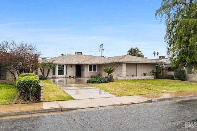 ranch-style house featuring driveway, a front yard, fence, and stucco siding